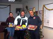 Pam Dryer, Ashland NFWCO, along with Ashland Firefighters Casey Bielen adn Jon Paulson show off several of the toys collected by the Ashland NFWCO, National Park Service Great Lakes Network Office and USGS Lake Superior Biological Office.