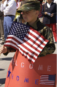 boy with American flag and welcome home sign