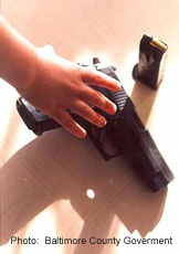 Photograph of a hand reaching for a gun