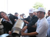 U.S. Ambassador Anne Derse and USAID's Yamashita pour first liters of milk to Chakhyrly's new milk storage tank.