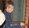 Teens repair the doorway of a pensioner's apartment