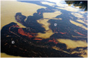 Aerial view of black dark oil on the Mississippi River, with small orangish streaks and patches of emulsified oil.