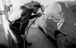 Image of worker spray painting a car