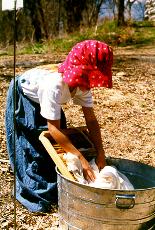 Girl dressed up as a homesteader pretending to wash clothes.