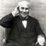 Thomas Edison with his hand to his ear.