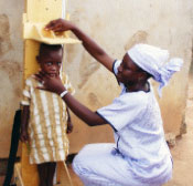 Photo of a woman measuring a child's height.