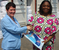 USAID Acting Director Catherine Andang, left, hands over a long lasting insecticide-treated mosquito bednet to Dr. Dorothée Yevide of Benin Ministry of Health. 