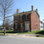 Two-story red brick house where Thomas and Mary Ann M'Clitnock lived.