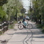 Bicyclist rides across narrow island community street.