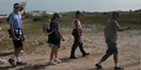 Group walks down the island behind the dunes.