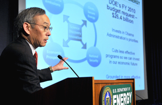 Secretary Chu discusses the DOE's Fiscal Year 2010 budget from a podium with his budget presentation behind him on a screen.