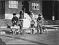 H0023-4. Gerald R. Ford, Jr. holds the reins of a pioneer wagon prior to participating in a neighborhood parade, while three unidentified cowboys stand nearby. 1923.