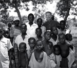 Figure 3 : The author poses with children in a village near Tororo, Uganda, during a 2003 mission of the US Department of Health and Human Services to observe the impact of HIV/AIDS in sub-Saharan Africa.