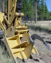 Photograph: blade mounted to heavy equipment Caterpillare 320.