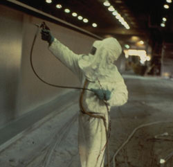 A painter applies a protective coating to a bridge to protect it from corrosion.
