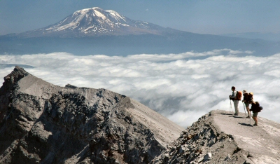 [ Photo ] USGS and Forest Service Scientists stand at the rim of Mount St. Helens during an August 2005 research trip.  In the distance is Mt. Adams..