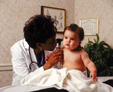 Photograph of a female doctor examining a baby