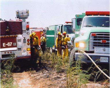 [Photograph]: Firefighting equipment and fire fighters.