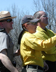 Two firefighters and a park ranger listen to briefing.