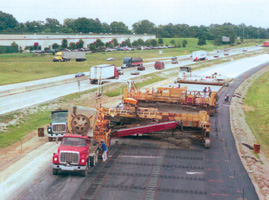 Typical concrete pavement construction view, with a slipform paver placing concrete.