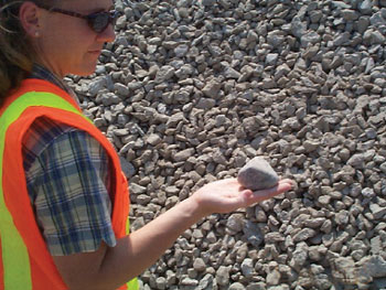 A member of the FHWA Recycling Team examines a recycled concrete aggregate (RCA) sample.