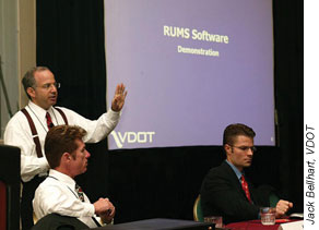 Brian Pierce (standing), BearingPoint senior manager; C.L. "Les" Griggs, Jr., VDOT IT section manager (left); and Derek Thompson, VDOT consultant, demonstrate RUMS at a Southeastern Association of State Highway and Transportation Officials (SASHTO) conference in August 2004.