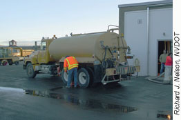 Worker inspecting tank truck. Richard J. Nelson, NVDOT