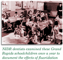 Photo: kids in a classroom. Text: NIDR dentists examined Grand Rapids schoolchildren once a year to document the effects of fluoridation