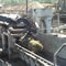 Picture of a bundle of woody biomass being fed into a chipper