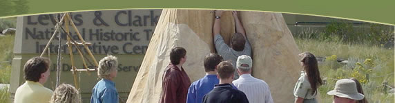 Photo of visitors watching as a tipi is erected outside the Interpretive Center. 