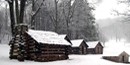The huts used by Washington's guard, framed by falling snow.