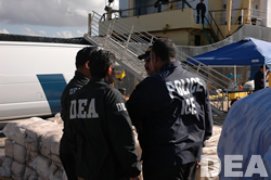 DEA and ICE agents stand guard over the seized cocaine.