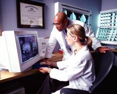 Fotografía de dos médicos analizando una imágen de resonancia magnética del cerebro