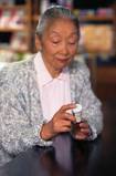 Woman reading a prescription bottle label. - Click to enlarge in new window.