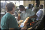 Photo thumbnail: Dental hygienists LCDR Vickie Owens (right) and CDR Sandra Ferguson (left) treat a child at Groves Elementary School in Guyana.