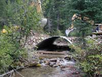 A rotation of pictures showing scenes from various Stewardship Contracting projects on various National Forests. These scenes include road reconstruction, fuels reduction, harvesting, log yard, stream improvement, and recreation area improvement activities.