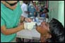 Photo thumbnail: Dental hygienists LTJG Nicole Langenderfer (left) and LTJG Paula Gomez (background) apply fluoride varnish to a patient in Port-au-Prince, Haiti.
