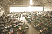 cots and people inside a large airplan hangar