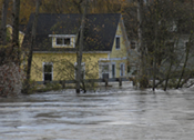 Yellow house surrounded by trees and floodwater