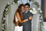 Wedding picture of a man and woman standing underneath an arch