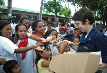 Photo:  LT Christine Nemeti, a health services officer, distributes toothbrushes to Vietnamese families shortly after the Corps? Pacific Partnership dental civic action program.  