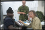 Photo thumbnail: CAPT Mary Reichler examines a police officer in Port-of-Spain, Trinidad.