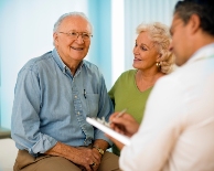 Picture of an older couple with a clinician on the foreground
