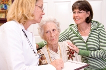 Picture of a clinician consulting with an elderly patient and family member