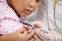 Close up picture of a young girl getting a finger prick