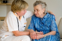 Picture of a clinician comforting and elderly woman