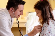 Picture of a clinician listening to a young girlâ€™s chest through a stethoscope