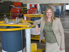 NASA Dryden engineer Starr Ginn shows off components of an aircraft jacking system that allows an aircraft to float during testing or maintenance.