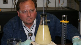 Governor Schweitzer Keeps an Eye on Beaker of Biofuel at College of Technology in Billings
