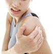 Young woman holding her shoulder in pain